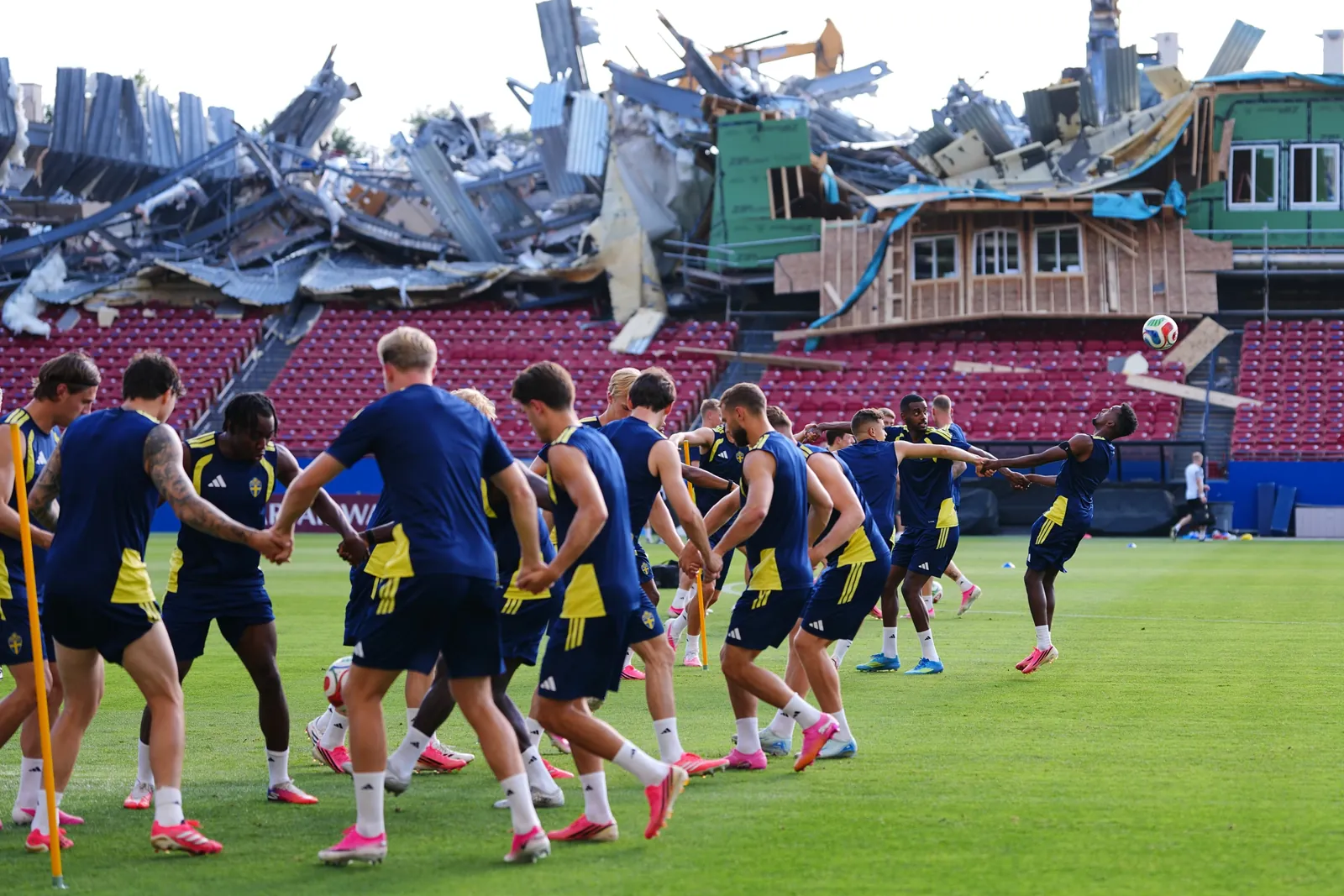 Demolition is visible to the stands at Toyota Stadium, home of MLS soccer's FC Dallas, as Sweden's Taha Ali, far right, tries to get to his head on the ball during a a training session ahead of Sweden's World Cup Group F soccer match against Japan, Wednesday, June 24, 2026, in Frisco, Texas. (AP Photo/Julio Cortez)