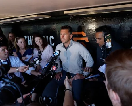 Buster Posey, president of baseball operations for the Giants, speaks to a group of reporters in the dugout on Thursday.