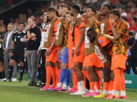 Ronald Koeman stands on the sideline with his players during the penalty shootout against Morocco