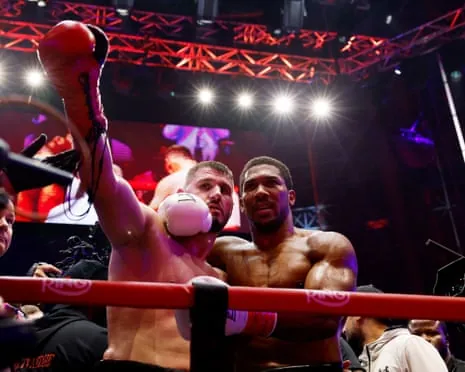 Anthony Joshua (right) embraces Kristian Prenga after winning his fight by technical knockout in the second round.