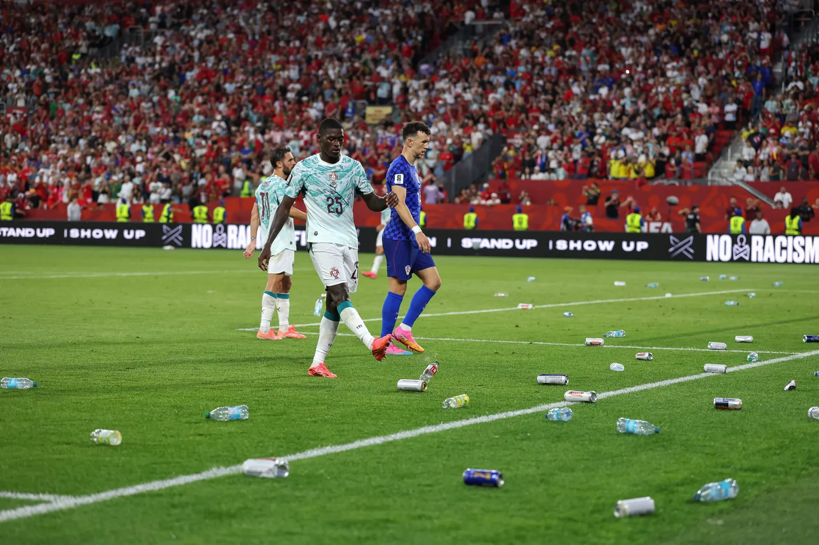 Bottles and cans thrown by fans are seen on the pitch during the FIFA World Cup 2026 Round of 32 match between Portugal and Croatia.